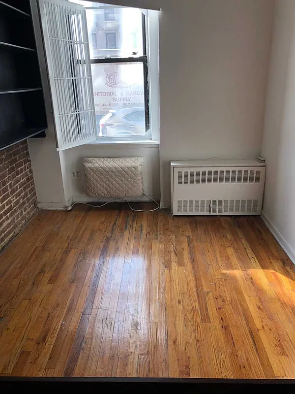 237 East 79th Street, Unit 1B Manhattan, NY 10075 - Photo 1 of 7 an empty room with wooden floor and windows