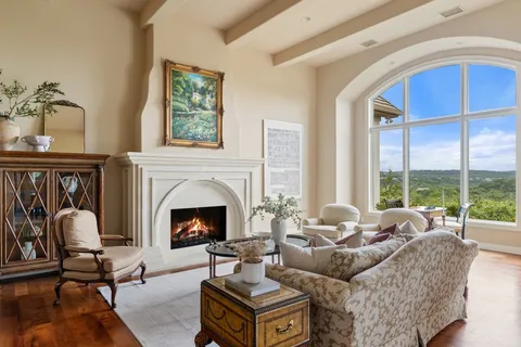 a living room with furniture a fireplace and floor to ceiling window