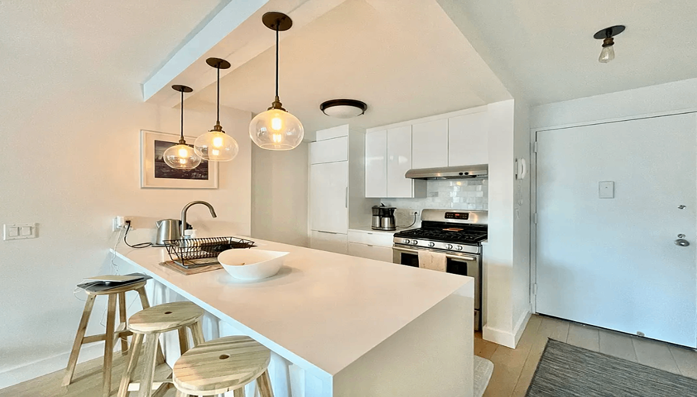 a kitchen with kitchen island a dining table and chairs