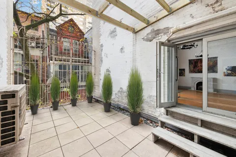 a view of a porch with a bench and potted plants