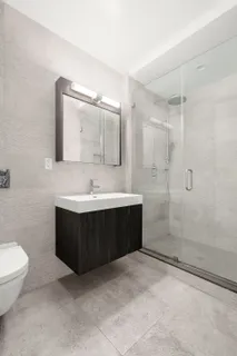 a bathroom with a bathtub shower sink mirror and toilet