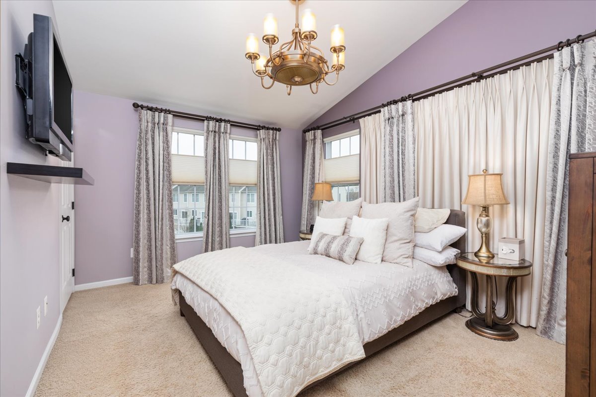 25436 South Riding Boulevard Chantilly, VA 20152 - Photo 5 of 8 a bedroom with a bed and a chandelier