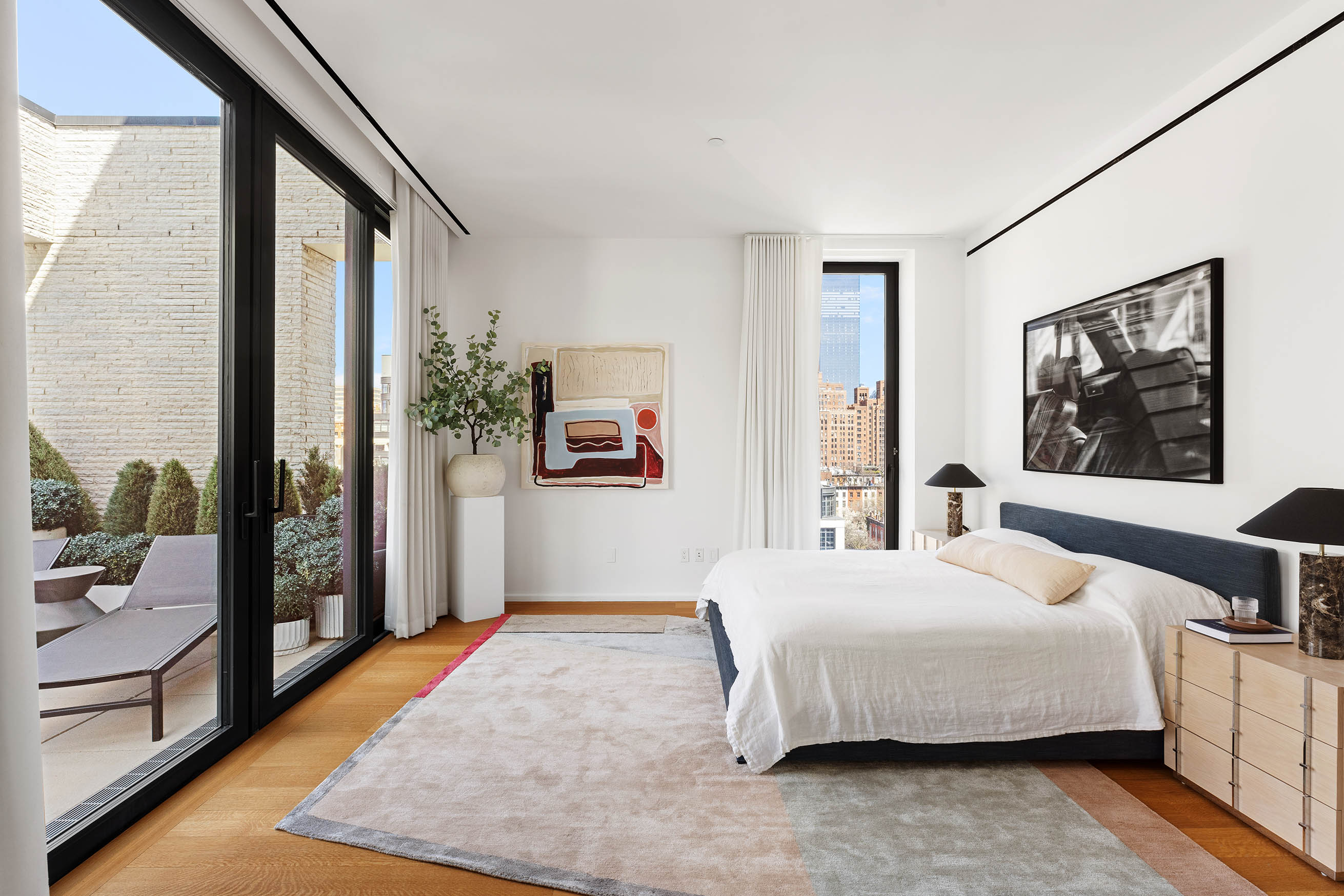 505 West 19th Street, Unit PH1 Manhattan, NY 10011 - Photo 11 of 26 a bedroom with a large bed and a large window