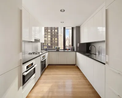 a kitchen with granite countertop a sink and a stove top oven