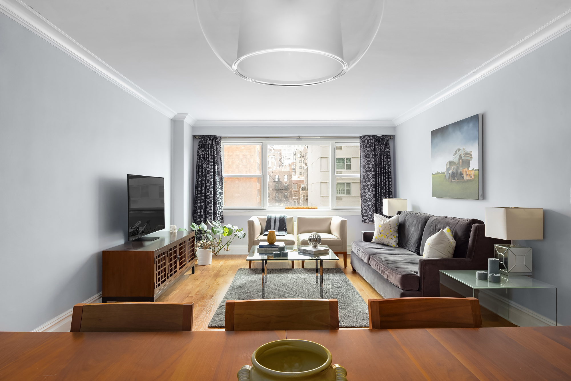 101 West 12th Street, Unit 8N Manhattan, NY 10011 - Photo 4 of 17 a living room with furniture and a flat screen tv