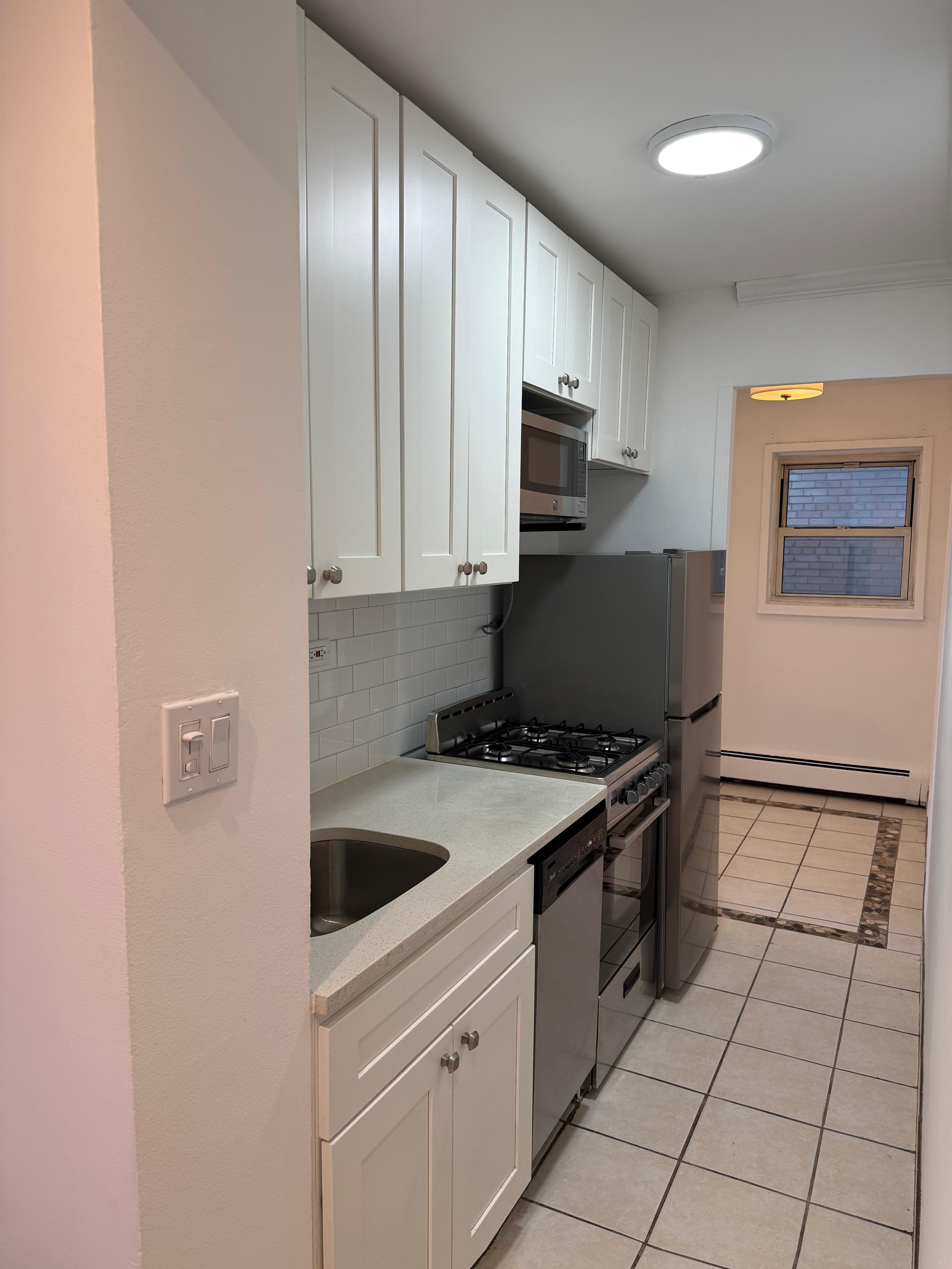 40 Sutton Place, Unit 7A Manhattan, NY 10022 - Photo 4 of 11 a kitchen with stainless steel appliances granite countertop a stove a sink and a refrigerator