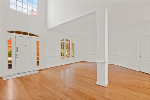 an empty room with wooden floor and window