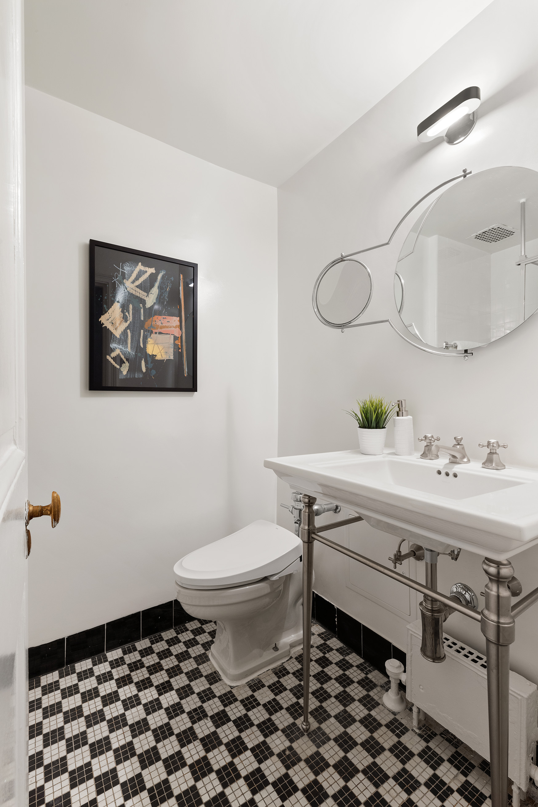 150 Central Park South, Unit 1010 Manhattan, NY 10019 - Photo 8 of 9 a bathroom with a sink toilet and mirror