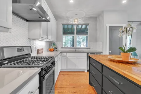 a kitchen with stainless steel appliances granite countertop a sink stove and cabinets