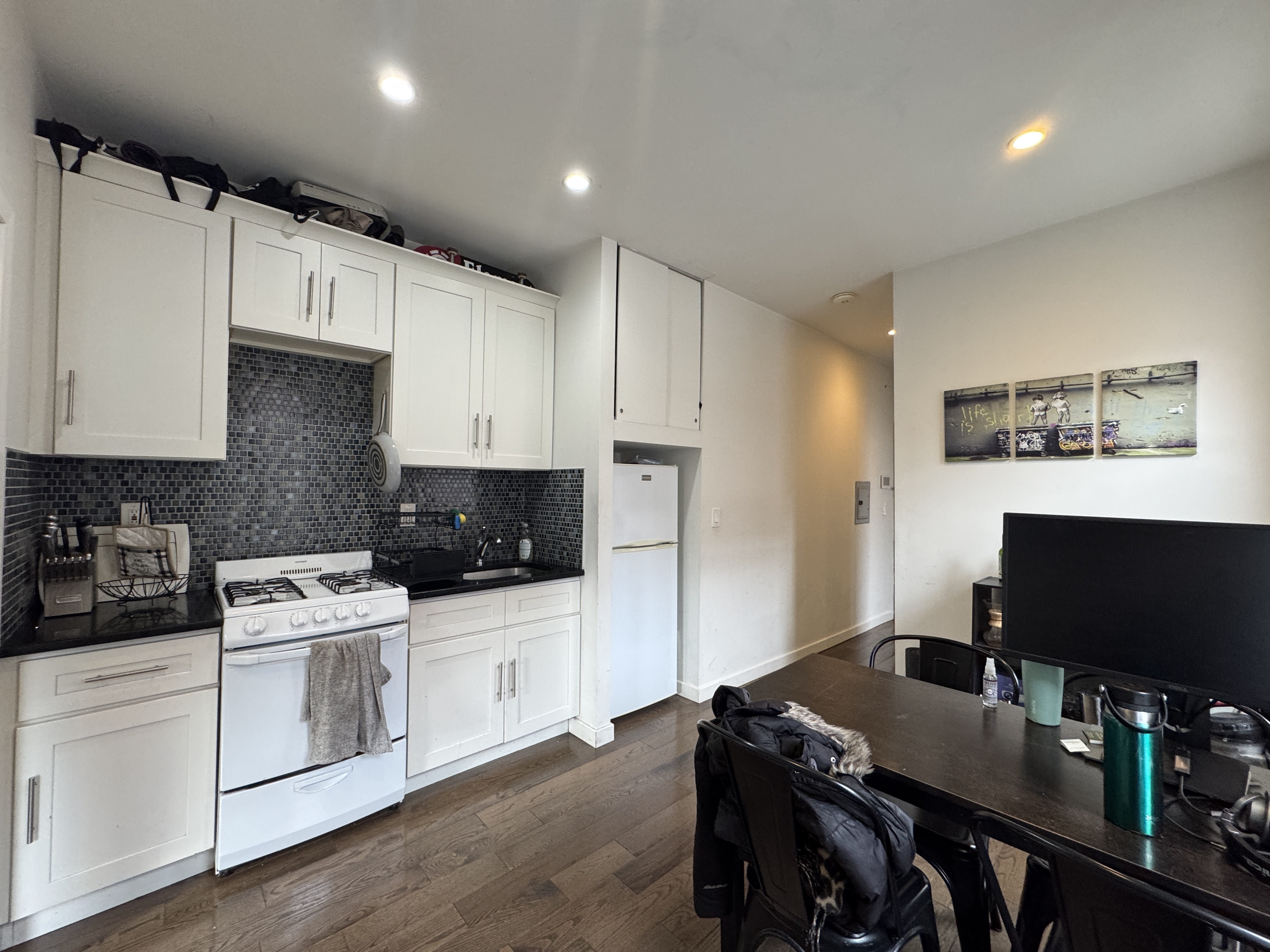 108 Stanton Street, Unit 1A Manhattan, NY 10002 - Photo 3 of 11 a kitchen with stainless steel appliances a stove a sink a microwave a refrigerator and cabinets