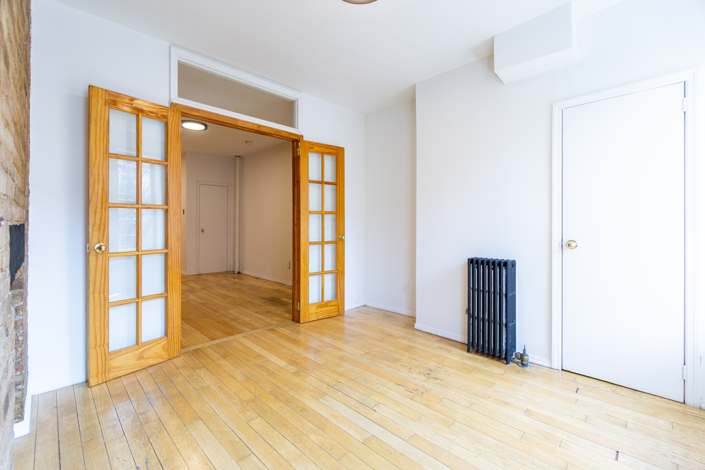 339 East 6th Street, Unit 12 Manhattan, NY 10003 - Photo 2 of 12 an empty room with windows and entryway