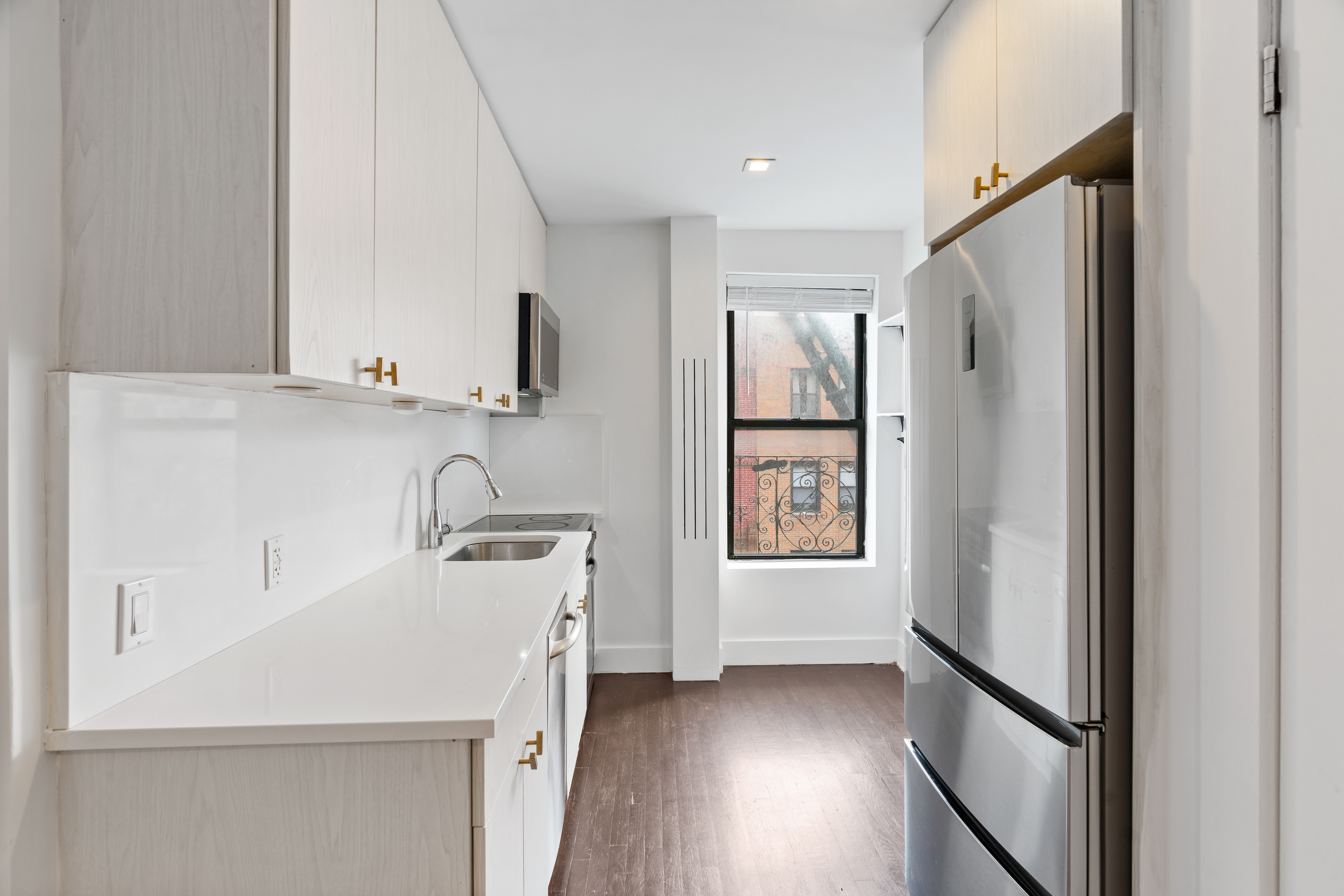 140 Orchard Street, Unit 14 Manhattan, NY 10002 - Photo 6 of 9 a kitchen with a refrigerator sink and cabinets