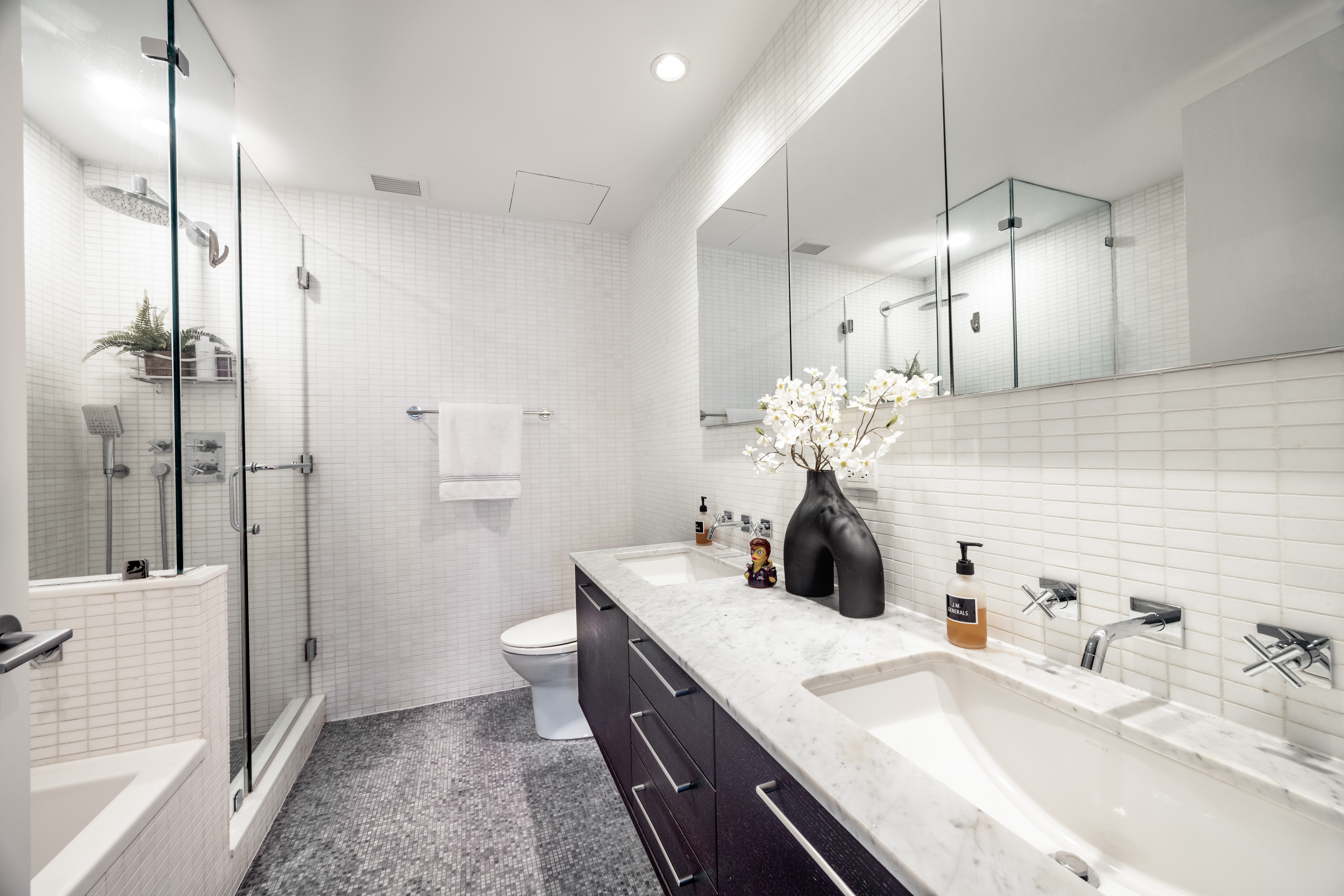 27 West 19th Street, Unit 6 Manhattan, NY 10011 - Photo 7 of 10 a bathroom with a double vanity sink mirror and toilet