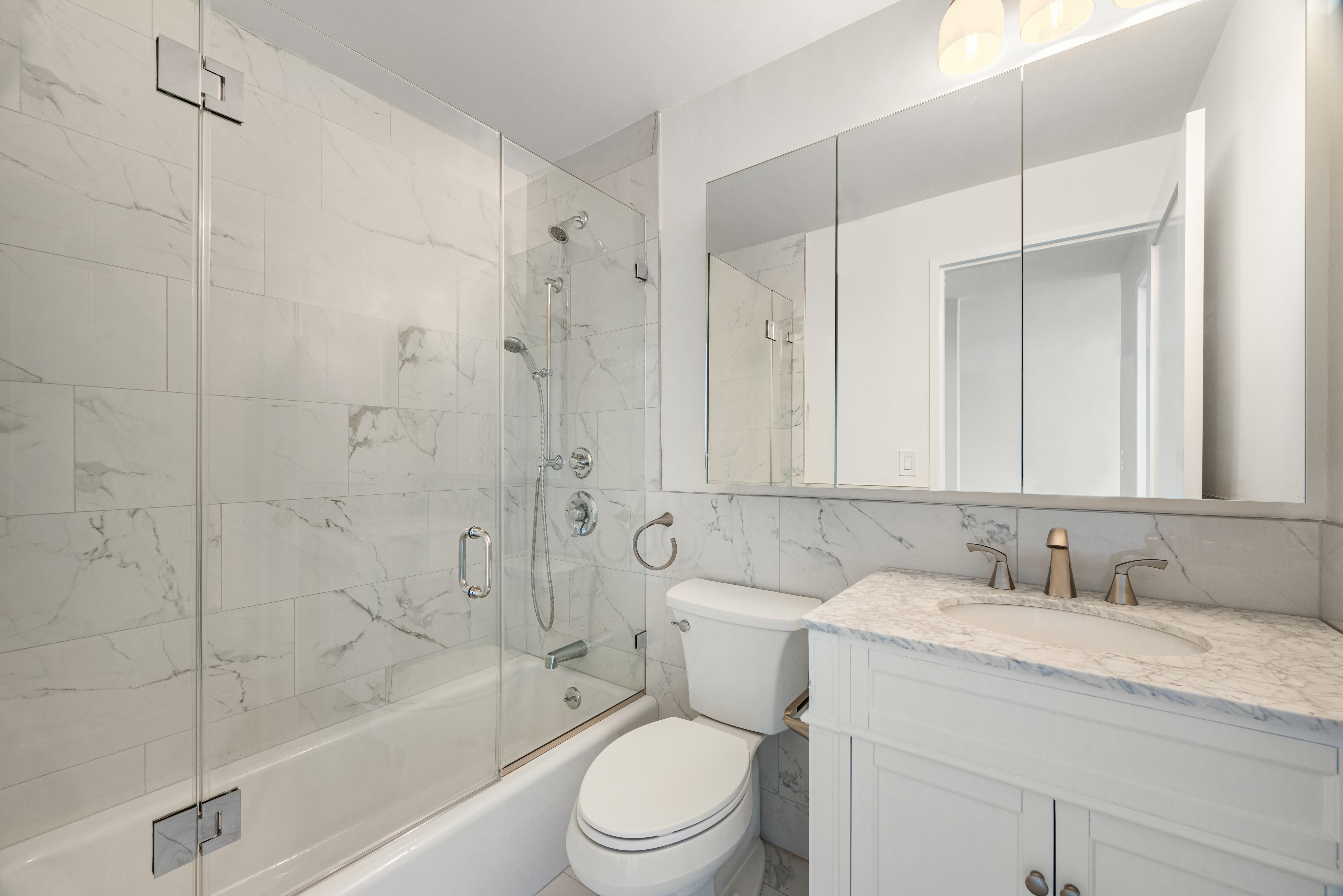 445 5th Avenue, Unit 26C Manhattan, NY 10016 - Photo 6 of 11 a bathroom with a granite countertop sink a toilet and shower