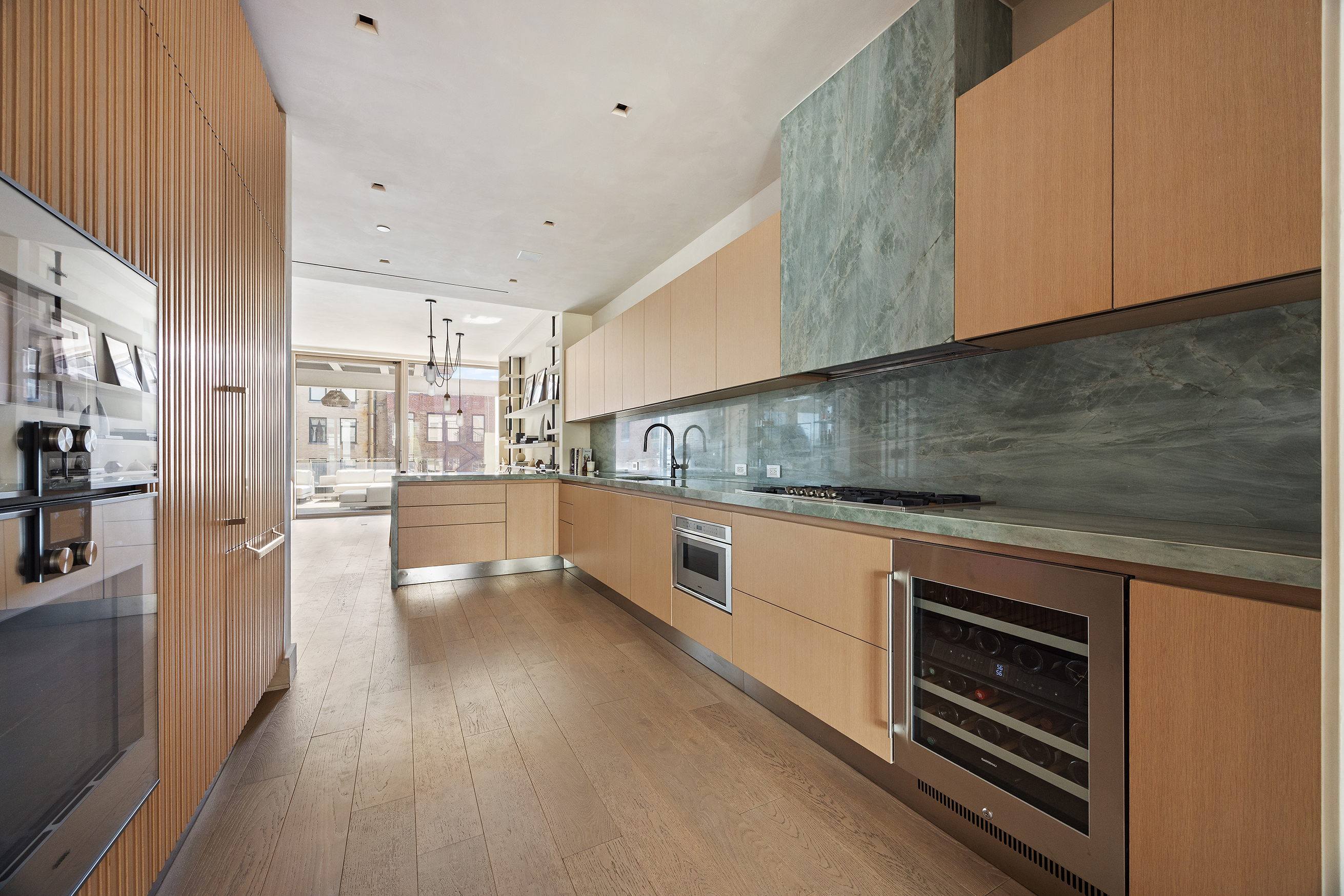 1 Great Jones Alley, Unit 10 Manhattan, NY 10012 - Photo 15 of 41 a kitchen with stainless steel appliances wooden floor sink and wooden cabinets