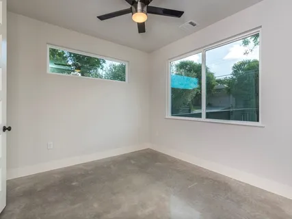 a view of empty room with window and ceiling fan