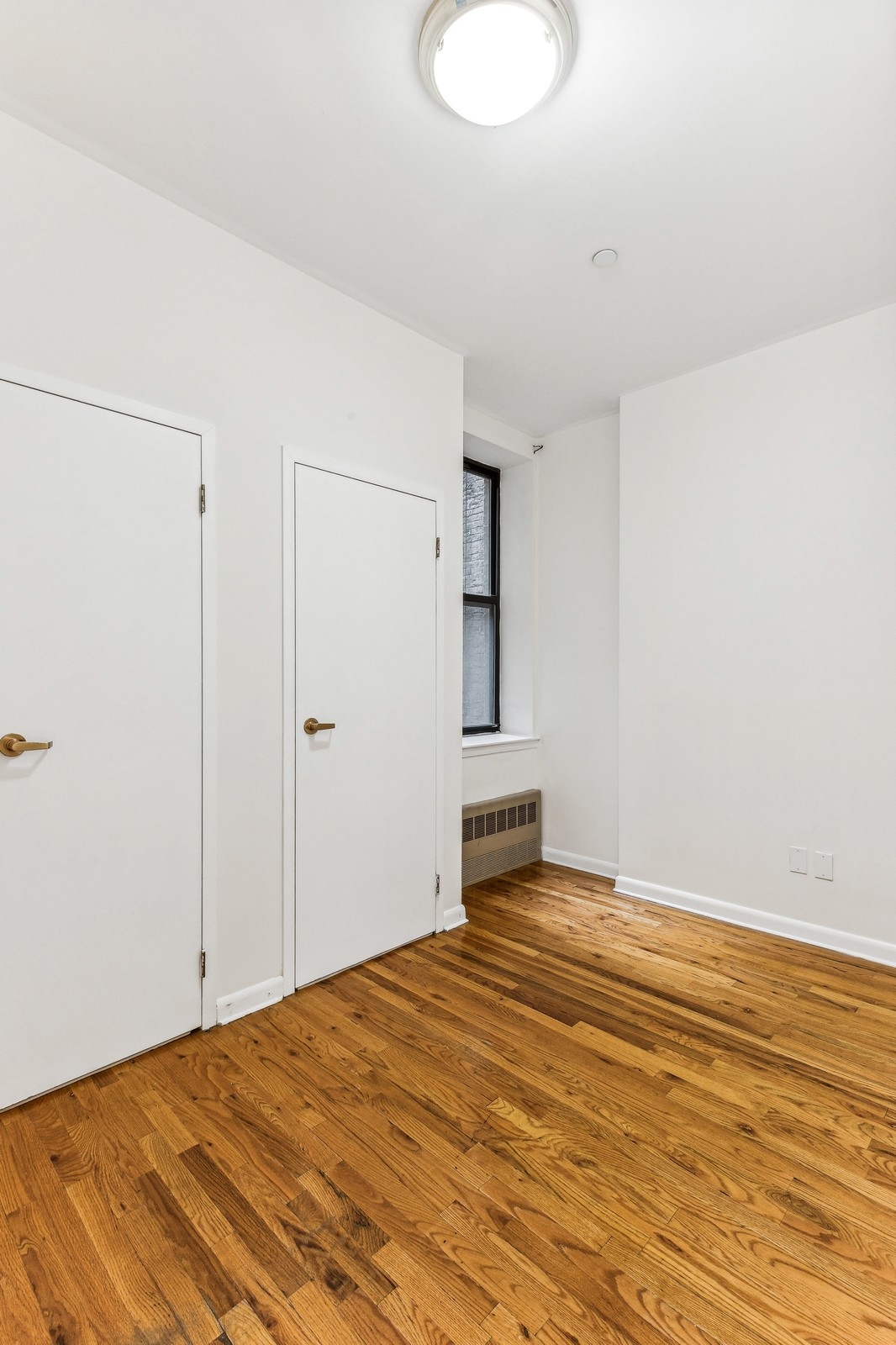 307 West 111th Street, Unit 2R Manhattan, NY 10026 - Photo 4 of 16 a view of a room with wooden floor and bathroom