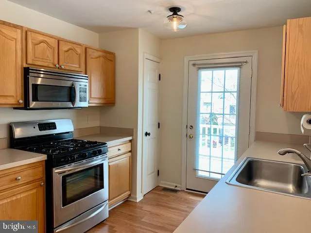 a kitchen with granite countertop a sink cabinets and stainless steel appliances