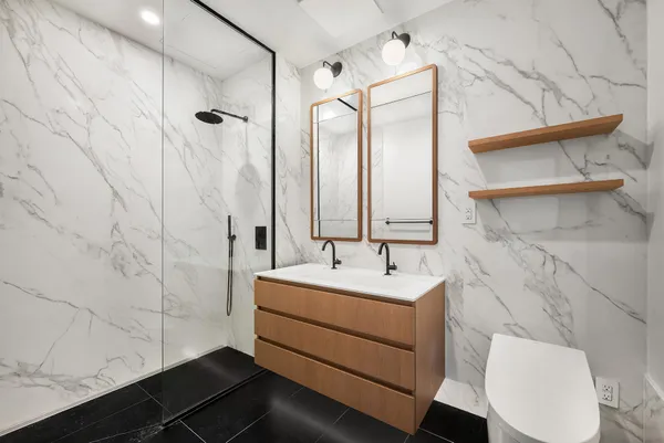 a bathroom with a sink a toilet and shower