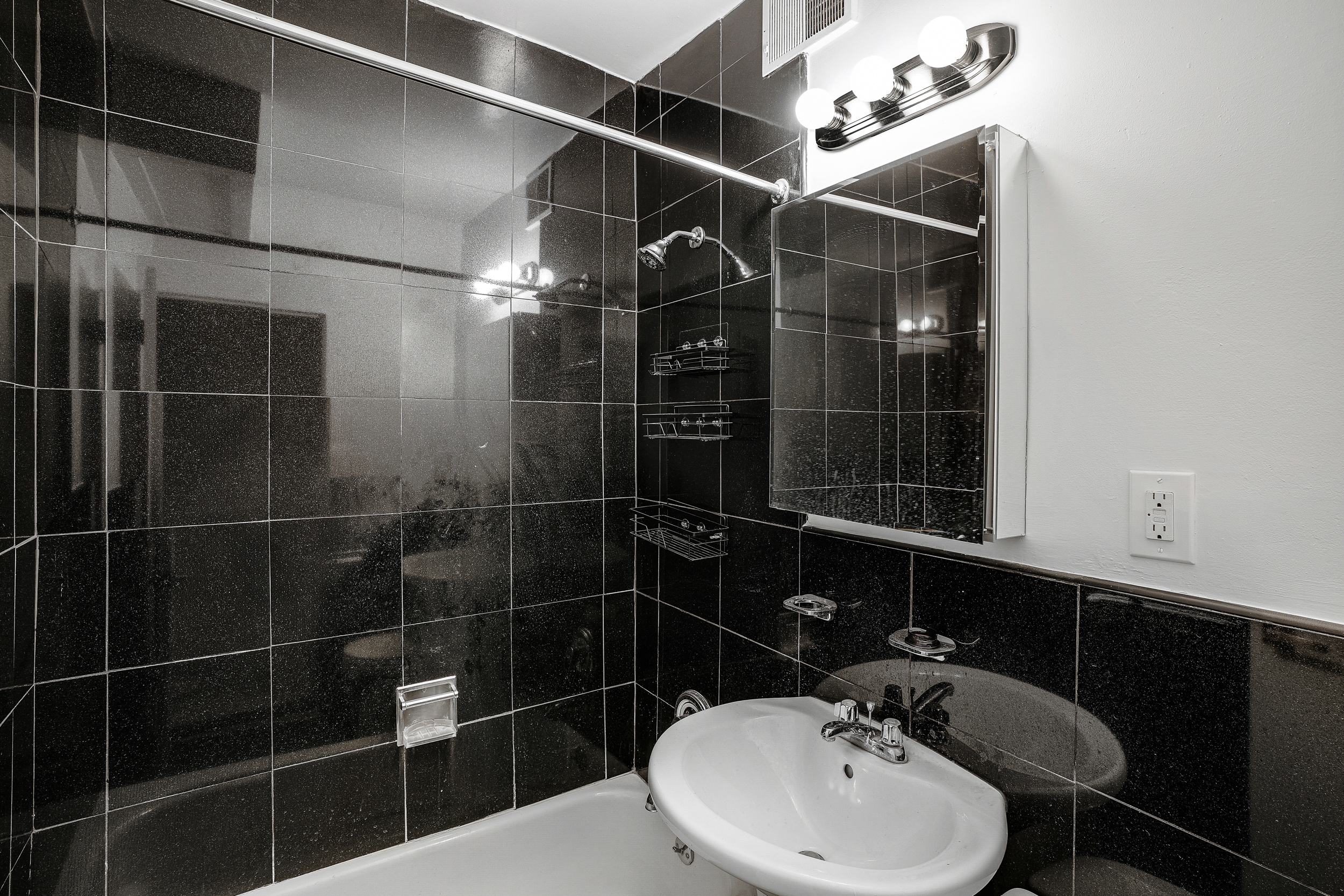 433 East 82nd Street, Unit 2B Manhattan, NY 10028 - Photo 5 of 5 a bathroom with a sink mirror and shower