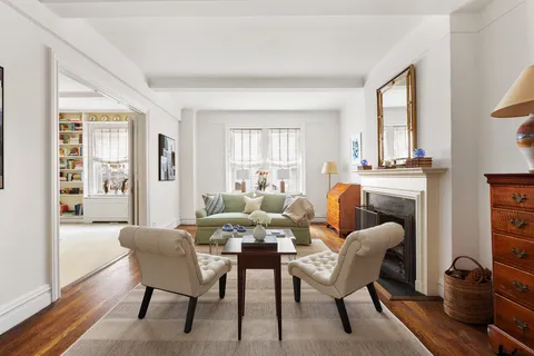 a living room with furniture a fireplace and large windows
