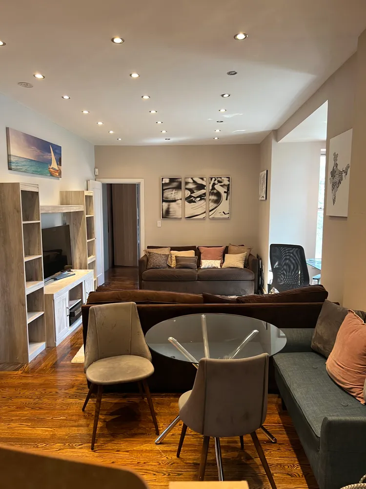 a living room with furniture a flat screen tv and kitchen view