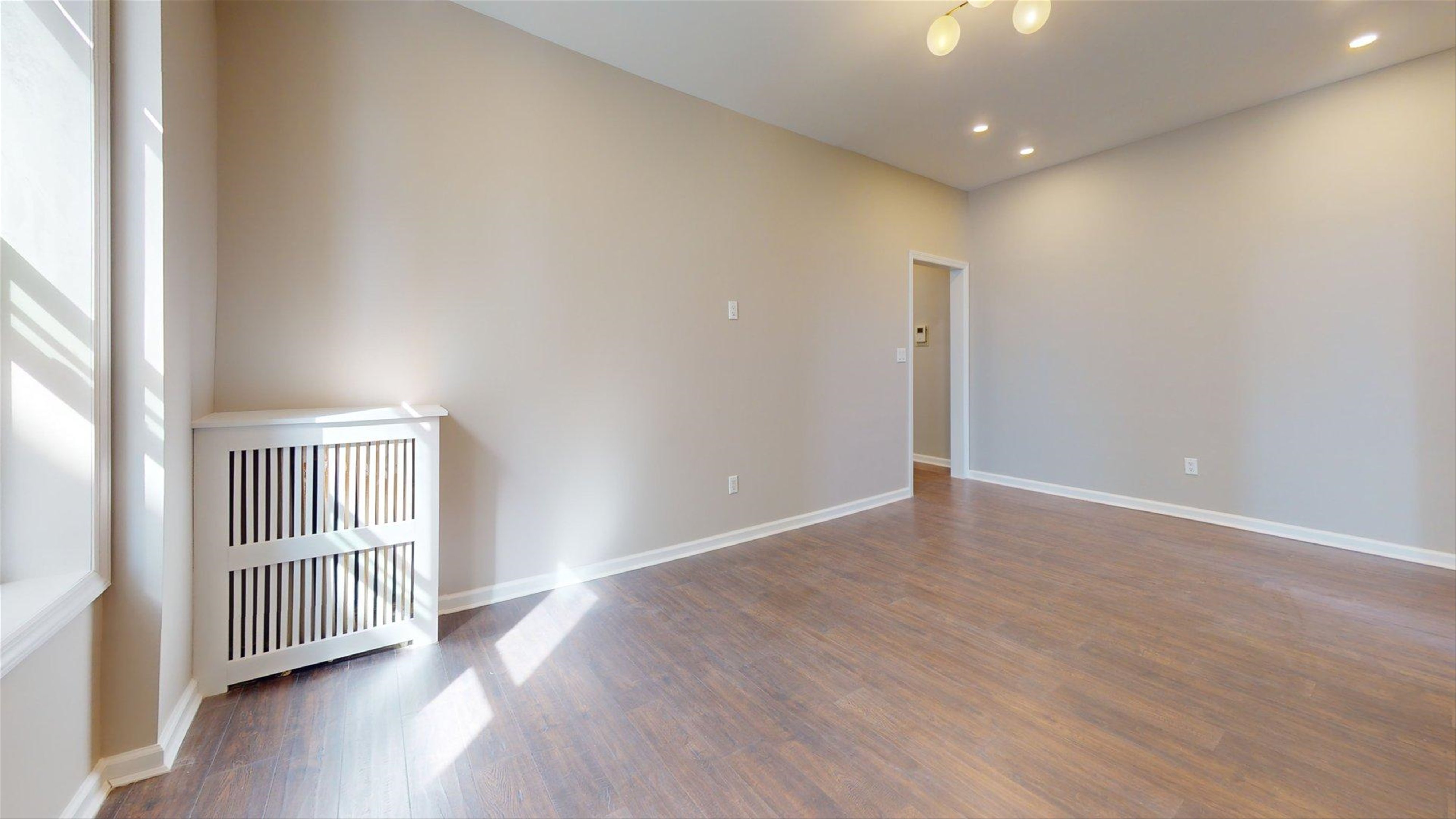 7609 4th Avenue, Unit E14 Brooklyn, NY 11209 - Photo 7 of 15 an empty room with wooden floor and a window