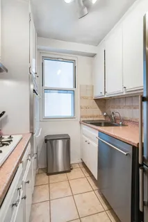 a kitchen with granite countertop a sink stove and cabinets