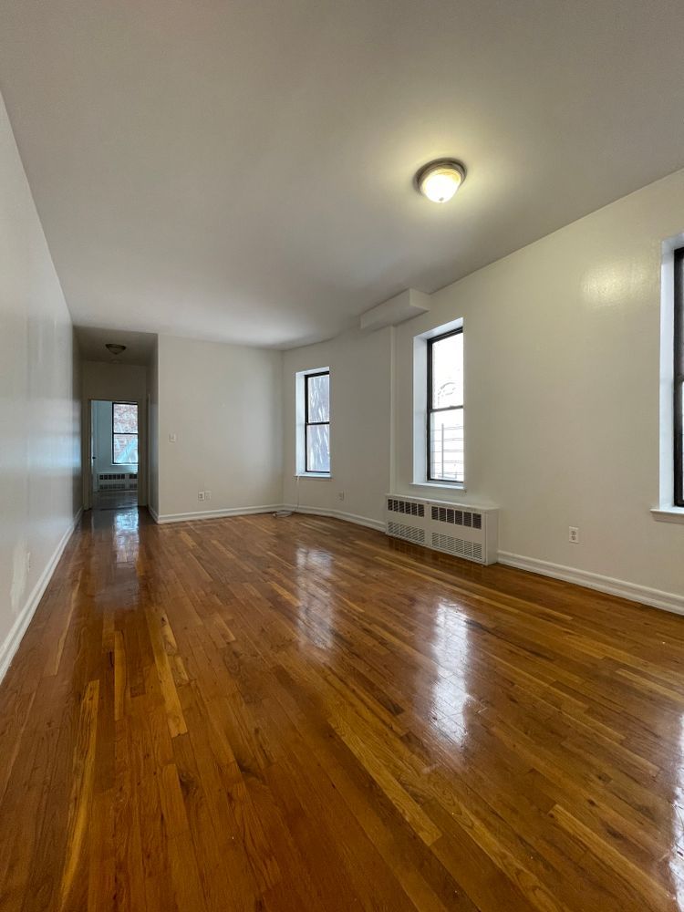 1280 Dean Street, Unit 3E Brooklyn, NY 11216 - Photo 5 of 5 an empty room with wooden floor and windows
