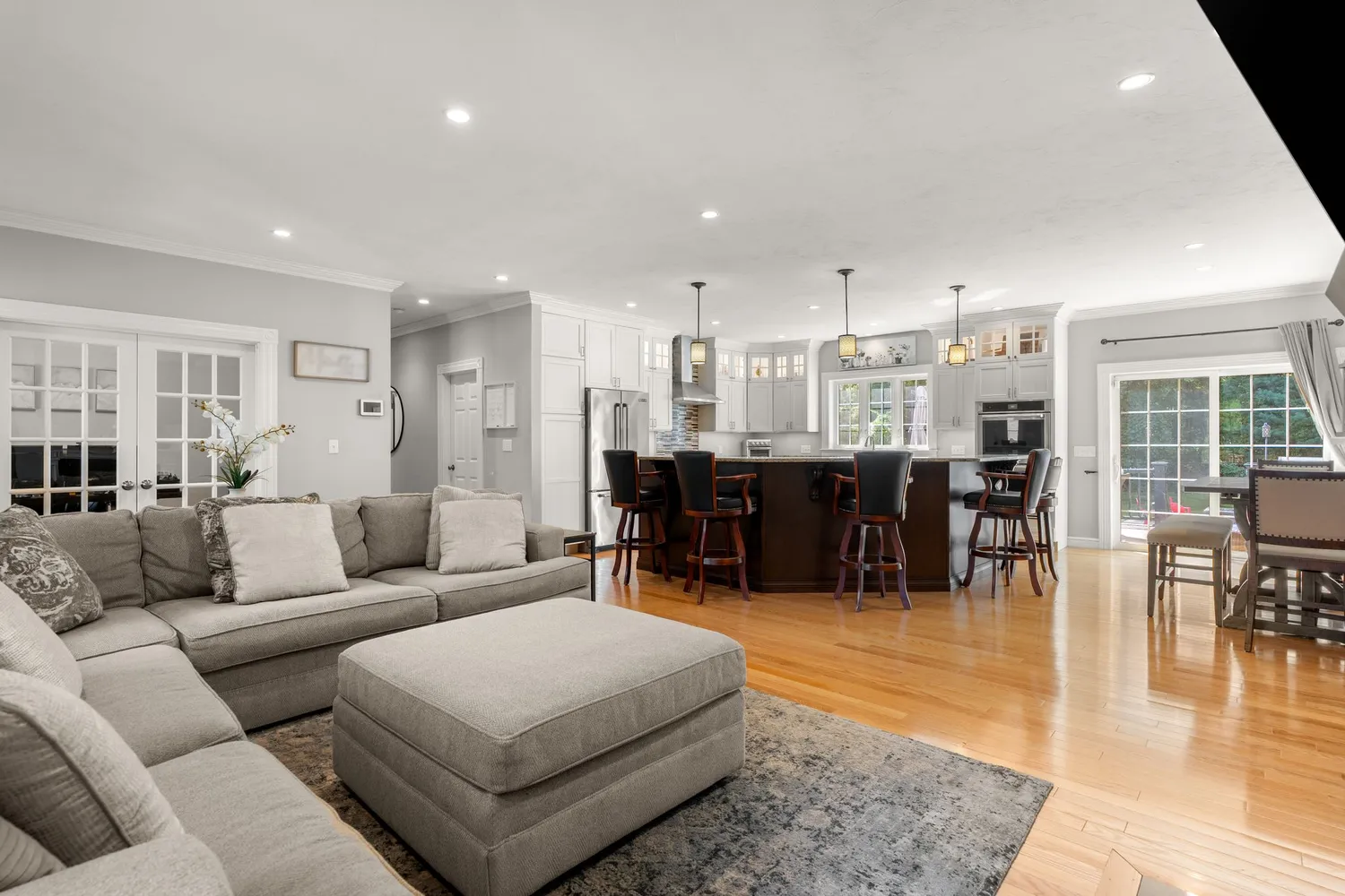 a living room with furniture and a dining table with wooden floor