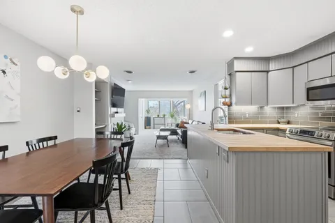 a kitchen with stainless steel appliances granite countertop a stove a sink a dining table and chairs