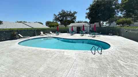 a view of swimming pool with table and chairs under an umbrella