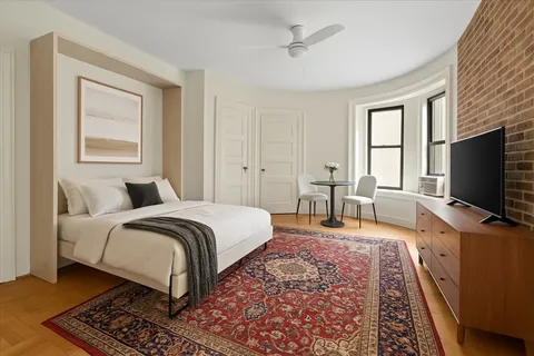 a spacious bedroom with a bed and a flat screen tv