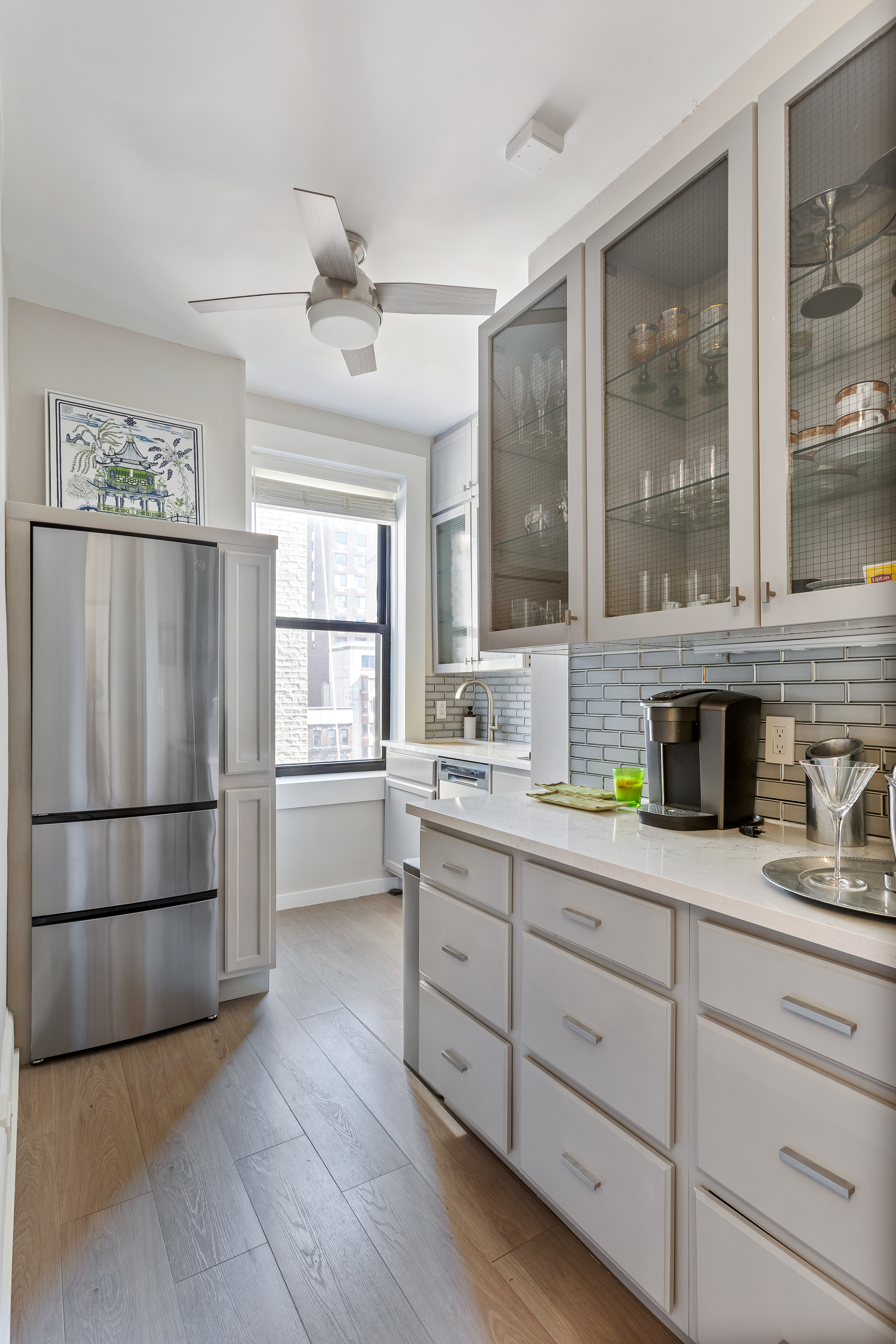 420 Riverside Drive, Unit 7K Manhattan, NY 10025 - Photo 3 of 7 a kitchen with stainless steel appliances granite countertop a refrigerator a sink a stove and white cabinets with wooden floor next to windows