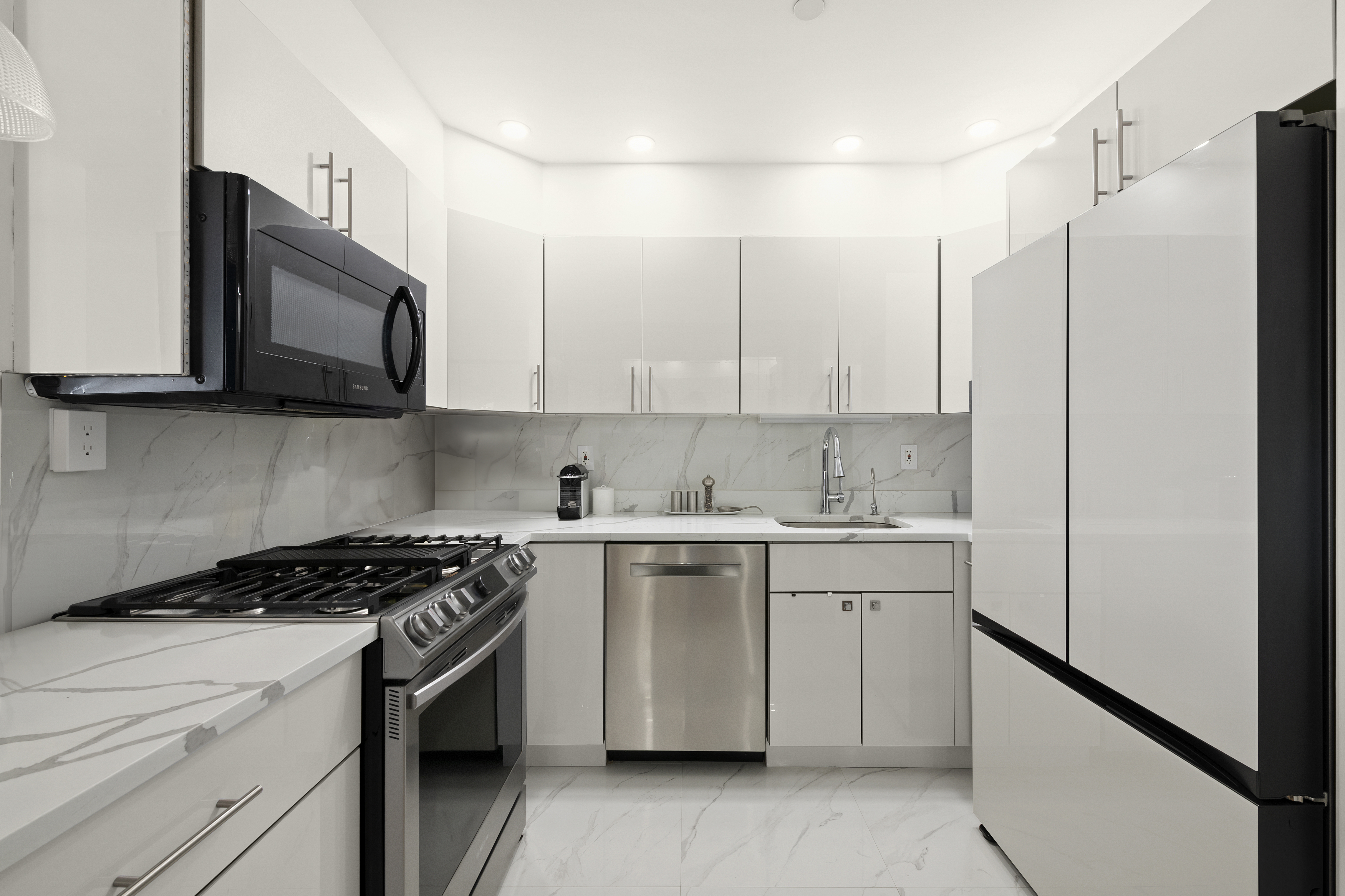 106 West 116th Street, Unit 10B Manhattan, NY 10026 - Photo 5 of 12 a kitchen with stainless steel appliances granite countertop white cabinets granite counter tops and a stove top oven