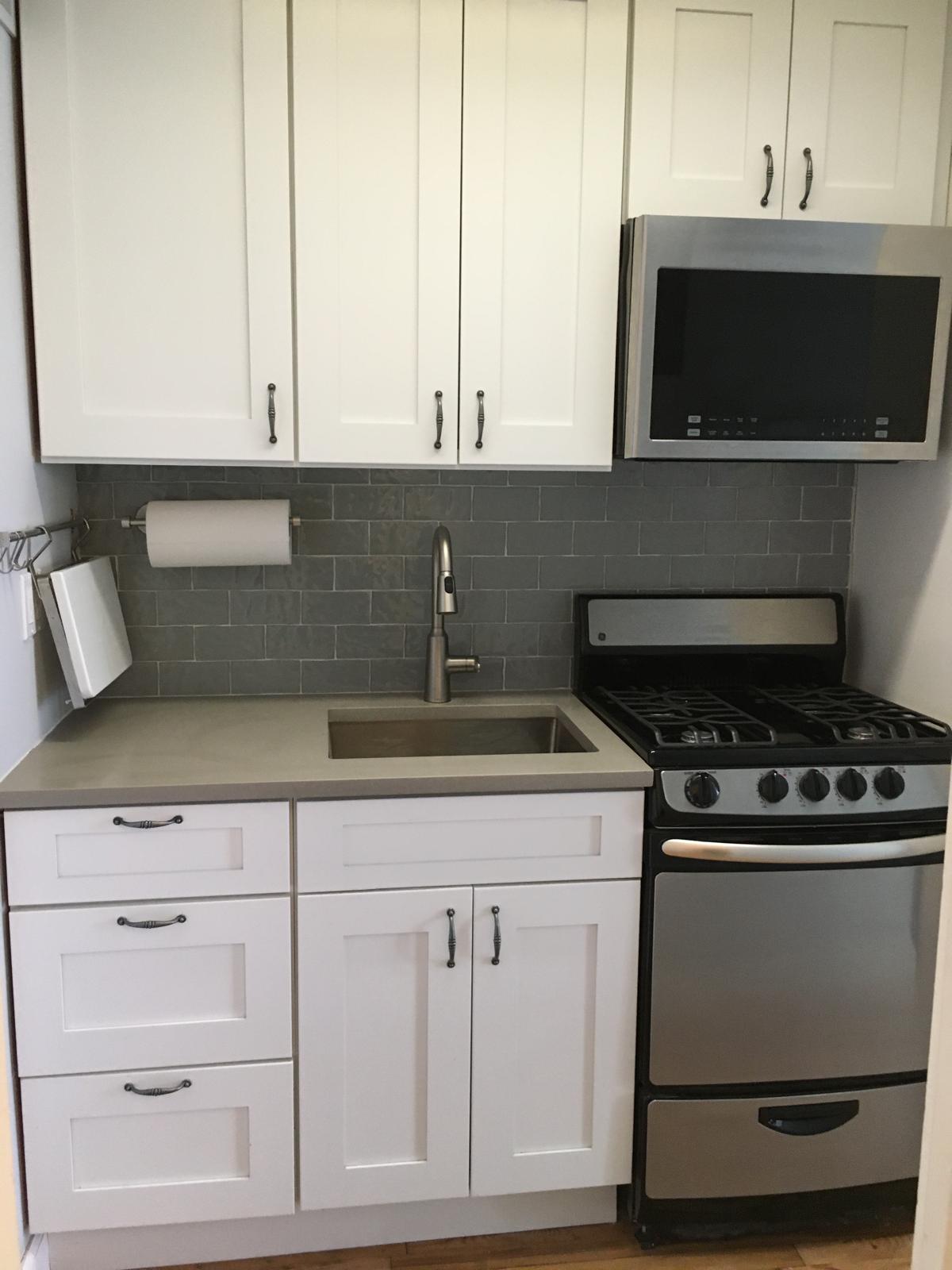 433 West 34th Street, Unit 7B Manhattan, NY 10001 - Photo 8 of 13 a kitchen with white cabinets and appliances