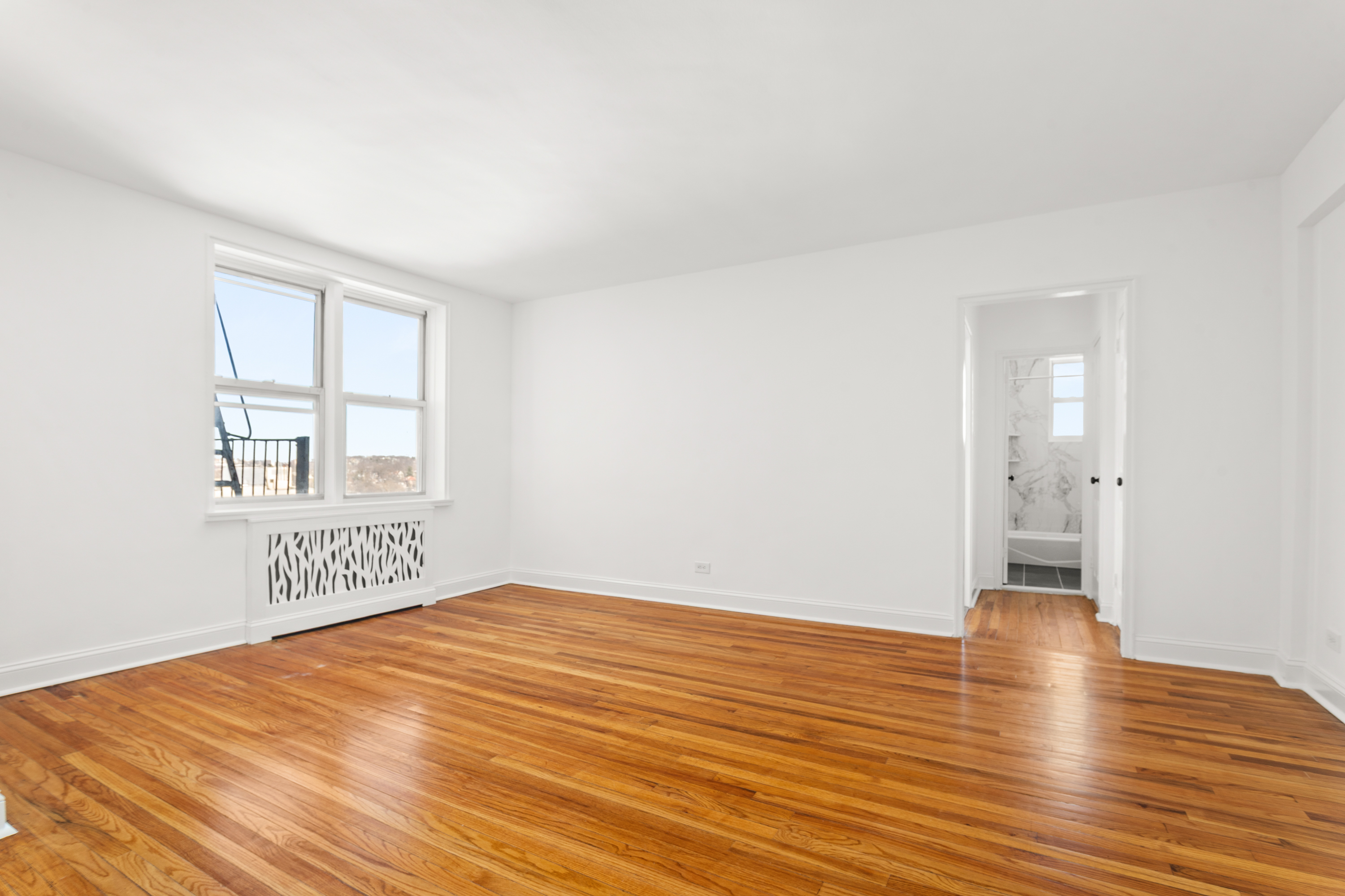 5650 Netherland Avenue, Unit 6C Bronx, NY 10471 - Photo 9 of 16 a view of an empty room with window and wooden floor