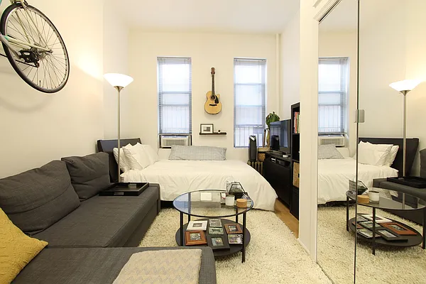 1313 3rd Avenue, Unit 2RN Manhattan, NY 10021 - Photo 1 of 4 a living room with furniture a large window and dining table