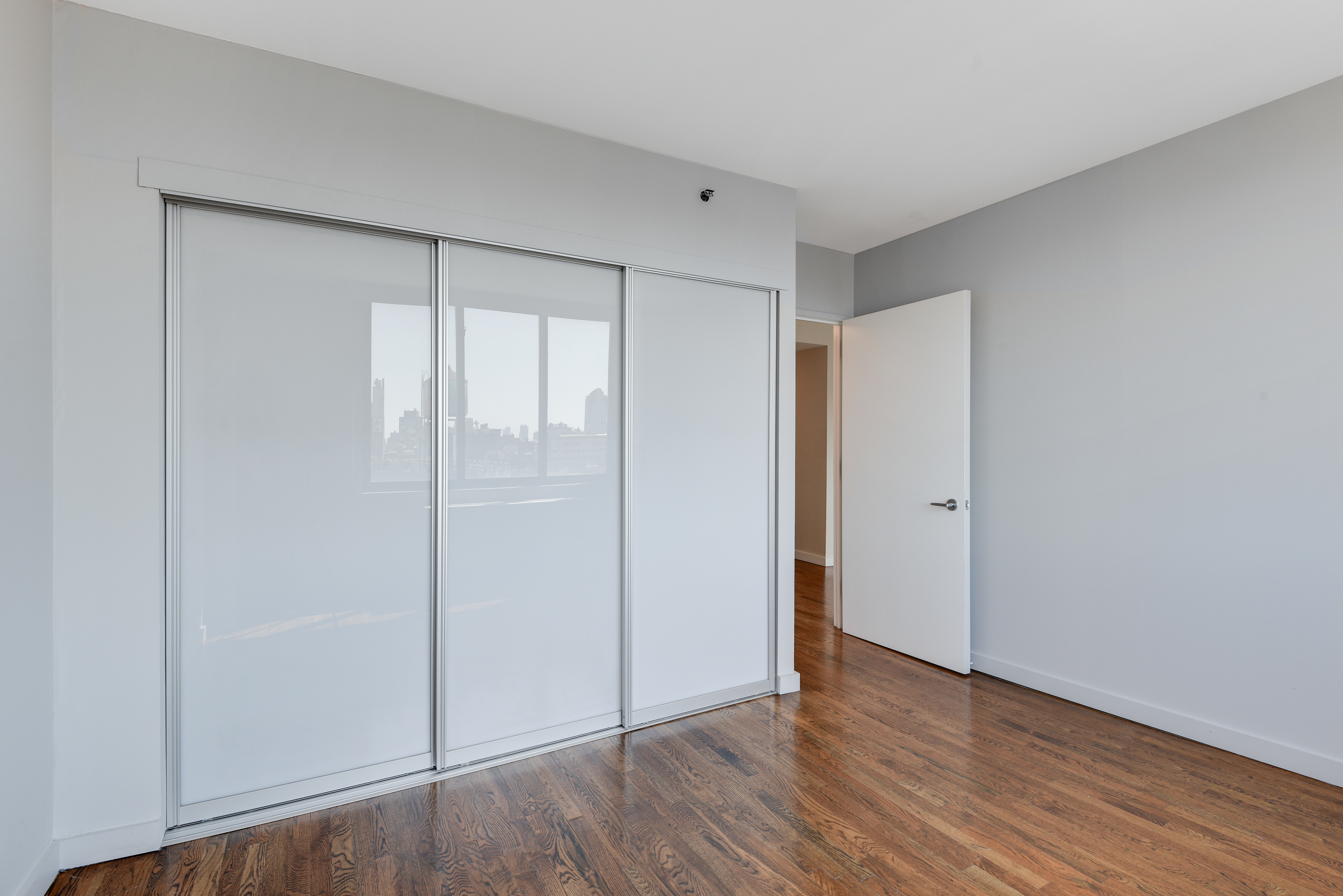 199 Bowery, Unit 11F Manhattan, NY 10002 - Photo 6 of 13 a view of an empty room with wooden floor