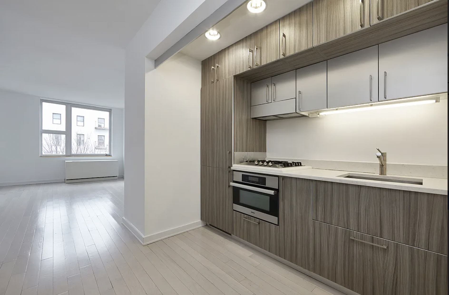 250 Bedford Avenue, Unit 129211 Brooklyn, NY 11249 - Photo 2 of 6 a kitchen with stainless steel appliances granite countertop a stove a sink and a microwave