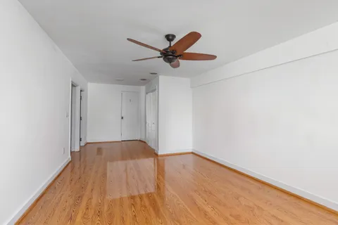 a view of empty room with wooden floor