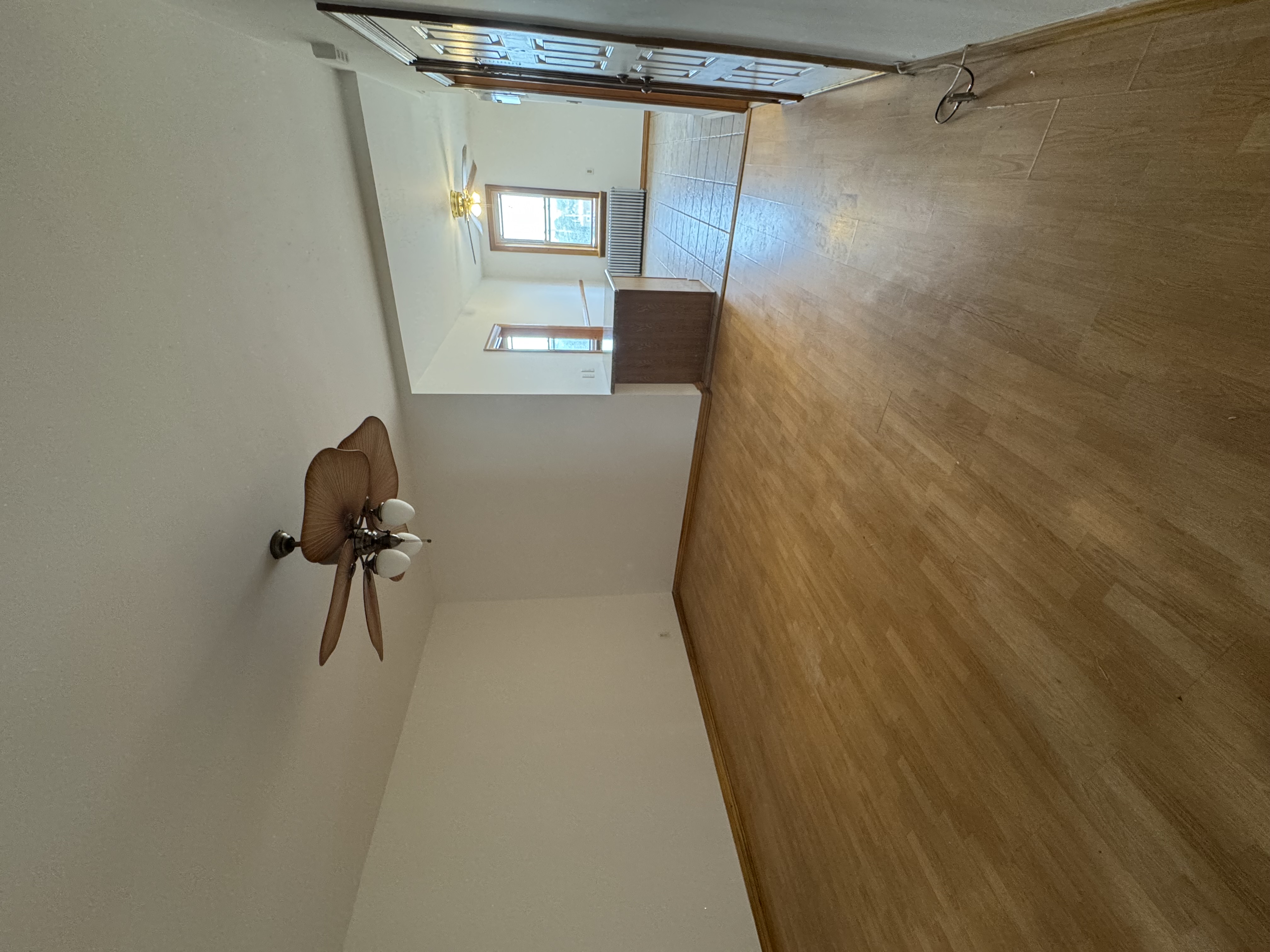 60-27 56th Road, Unit 3 Queens, NY 11378 - Photo 2 of 9 wooden floor in an empty room with a window