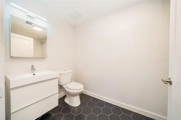 a bathroom with a toilet sink vanity and mirror