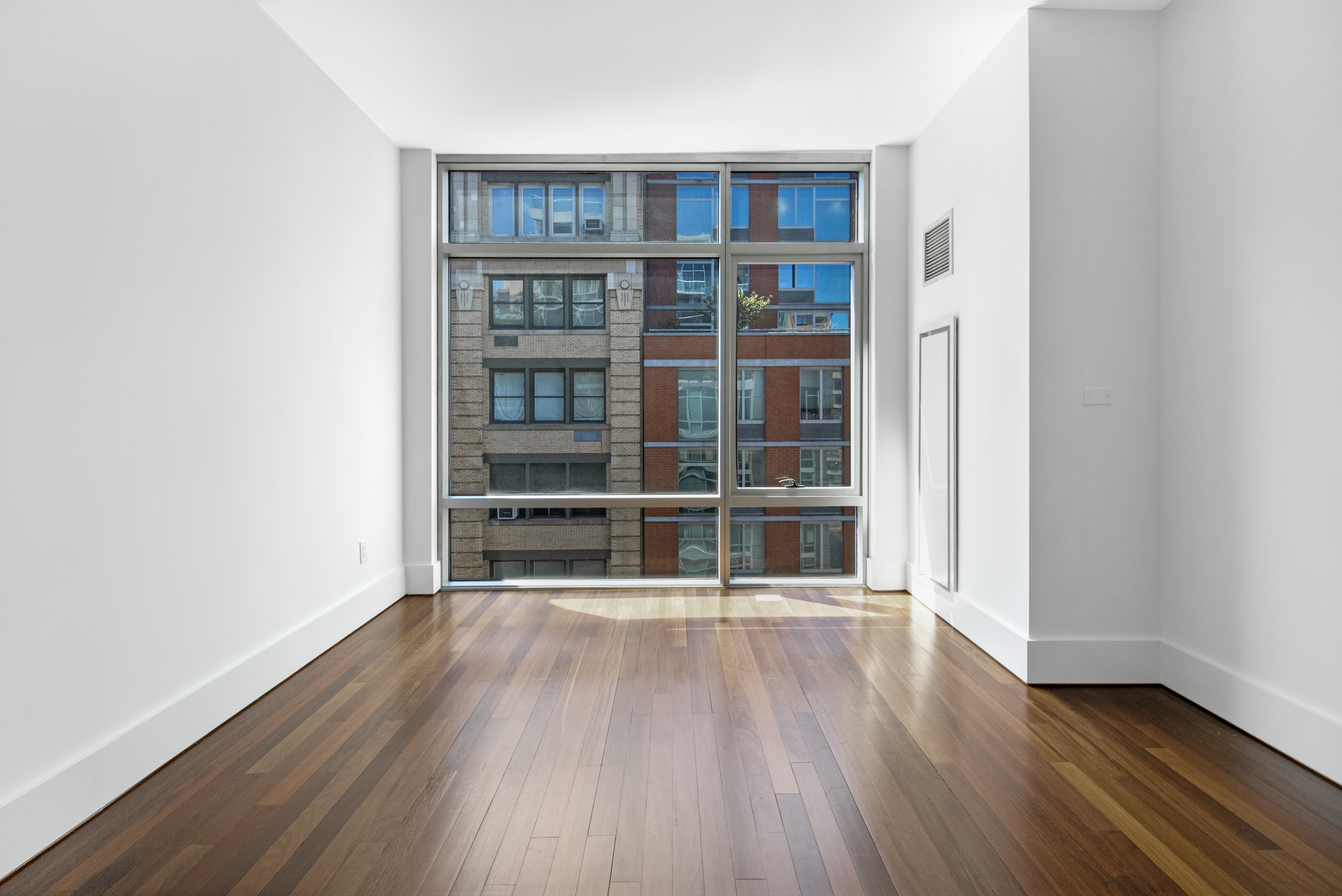 165 West 18th Street, Unit 8B Manhattan, NY 10011 - Photo 5 of 9 a view of a room with wooden floor and a window