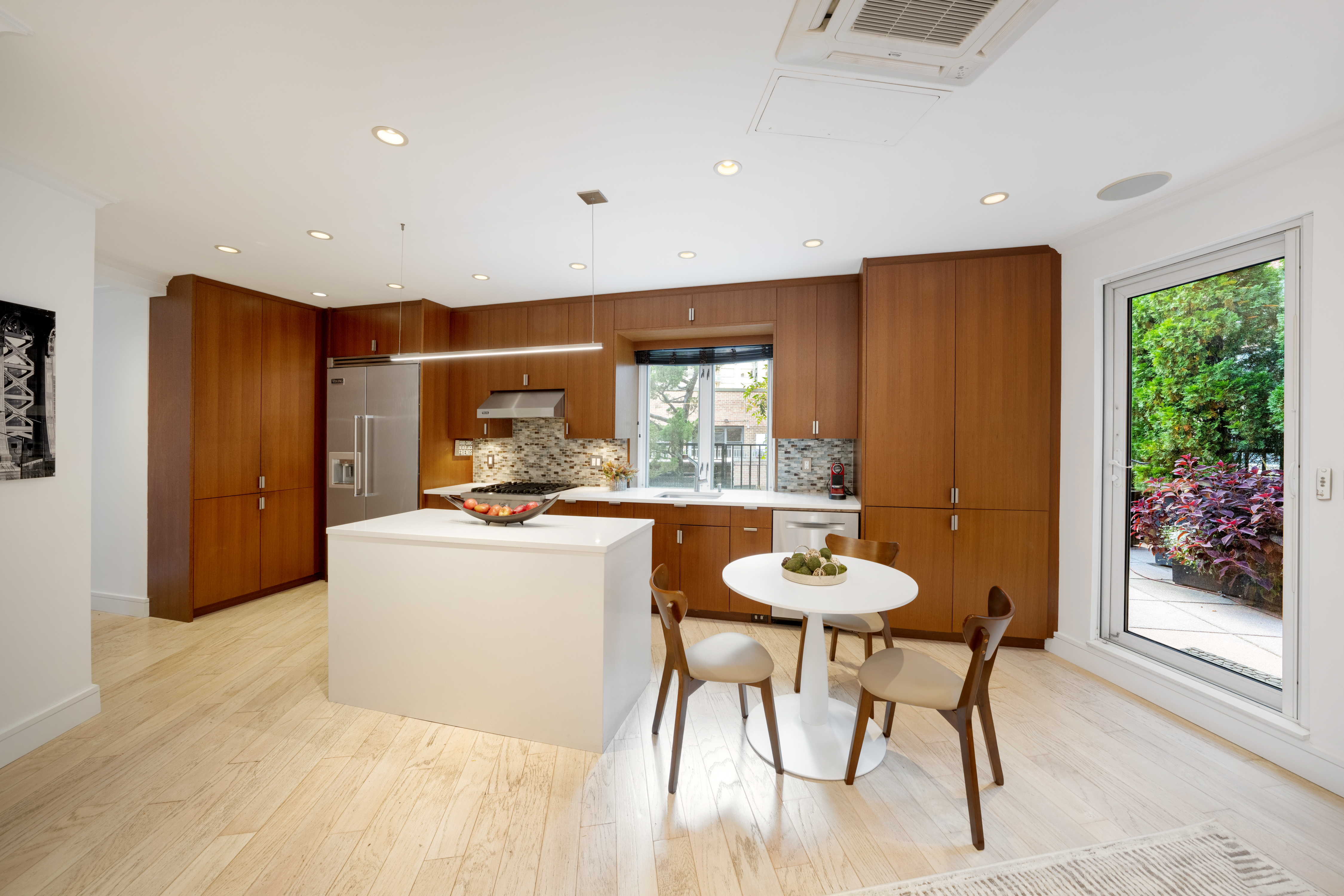 314 East 41st Street, Unit PH2B Manhattan, NY 10017 - Photo 8 of 13 a kitchen with stainless steel appliances granite countertop a table chairs and a refrigerator
