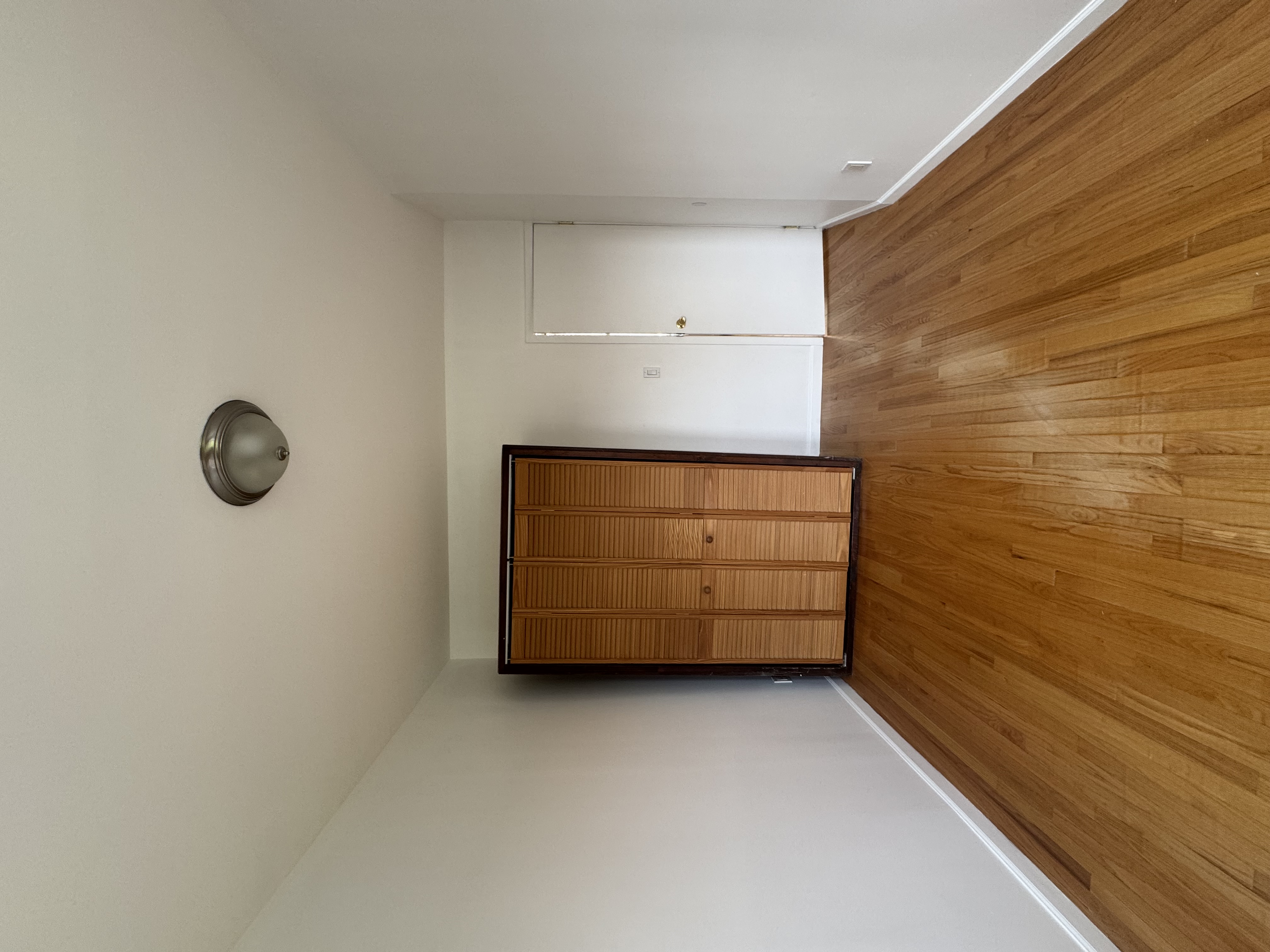 451 West 44th Street, Unit 63 Manhattan, NY 10036 - Photo 5 of 33 a view of an empty room with wooden floor and a window