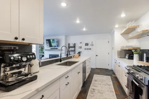 a kitchen with stainless steel appliances a stove a sink and a refrigerator