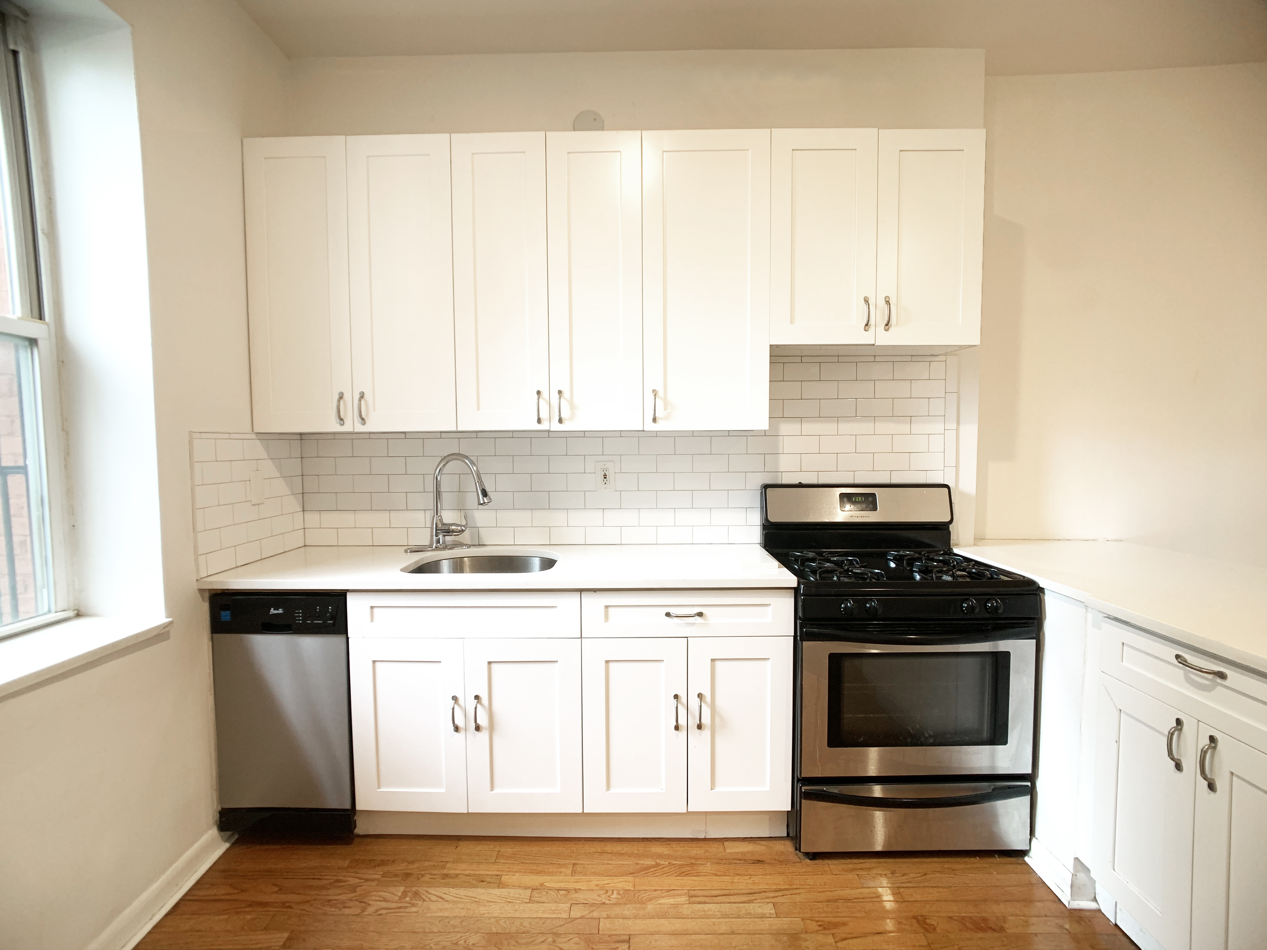 293 Tompkins Avenue, Unit 2 Brooklyn, NY 11221 - Photo 2 of 11 a kitchen with a sink stove and cabinets