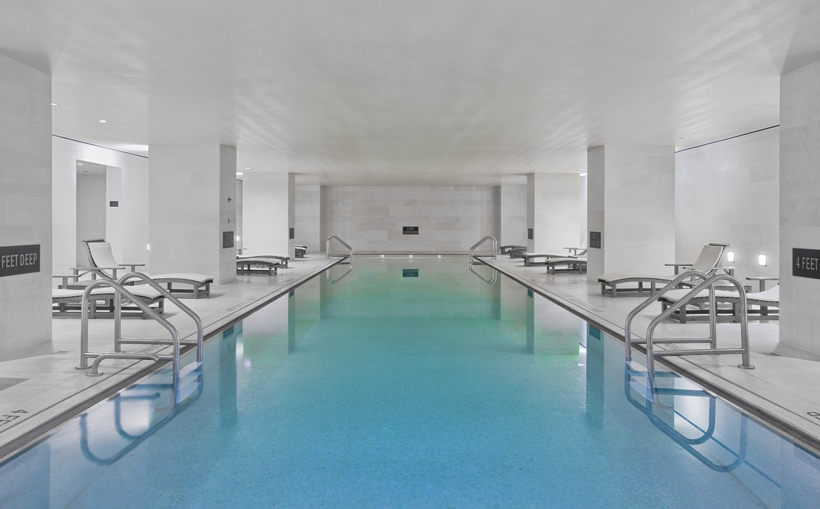 20 Pine Street, Unit 2413 Manhattan, NY 10005 - Photo 11 of 16 a large white kitchen with kitchen island lots of counter space a sink and chairs