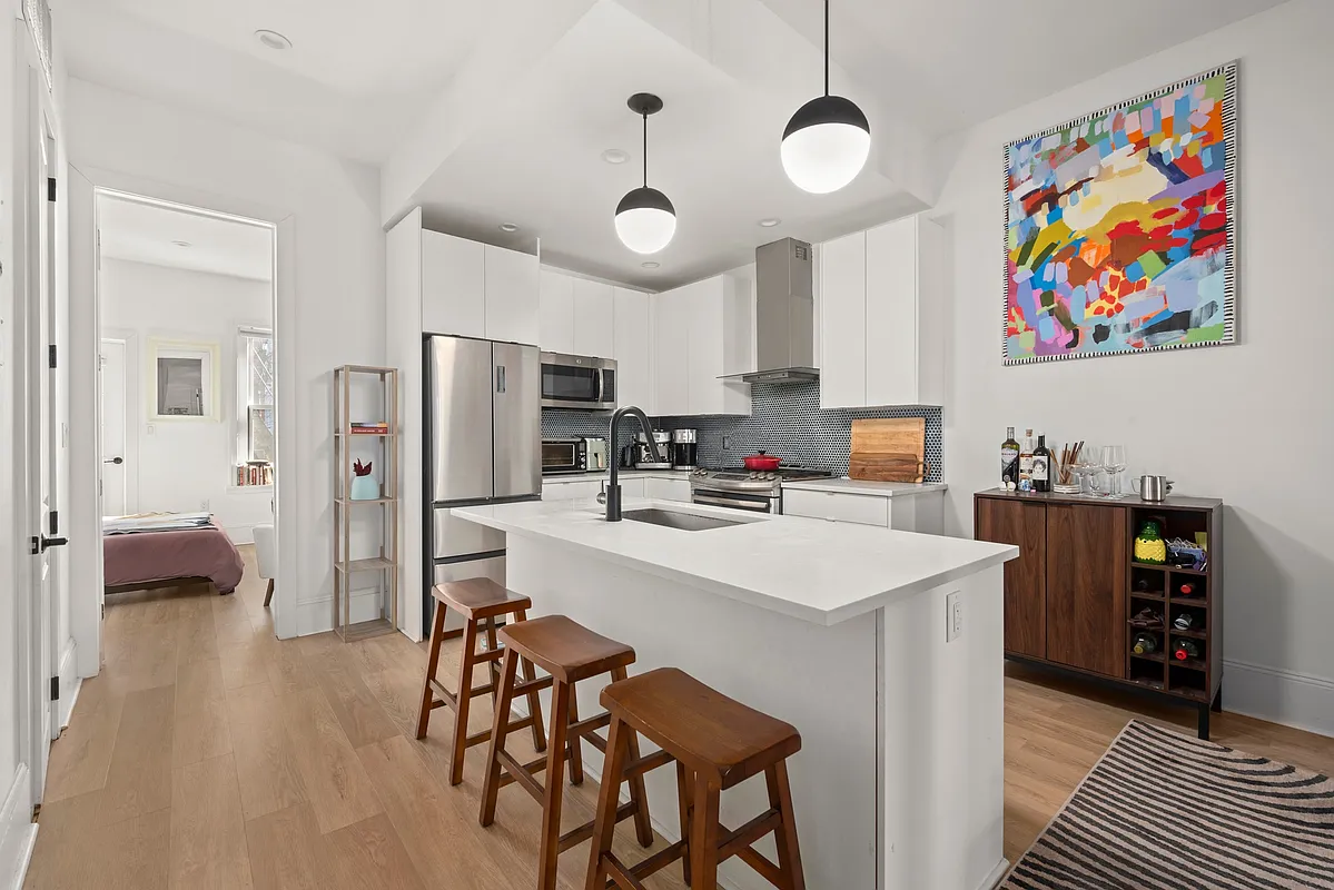 1316 Jefferson Avenue, Unit 2 Brooklyn, NY 11221 - Photo 2 of 10 a kitchen with stainless steel appliances a stove a refrigerator and a dining table with bookshelf